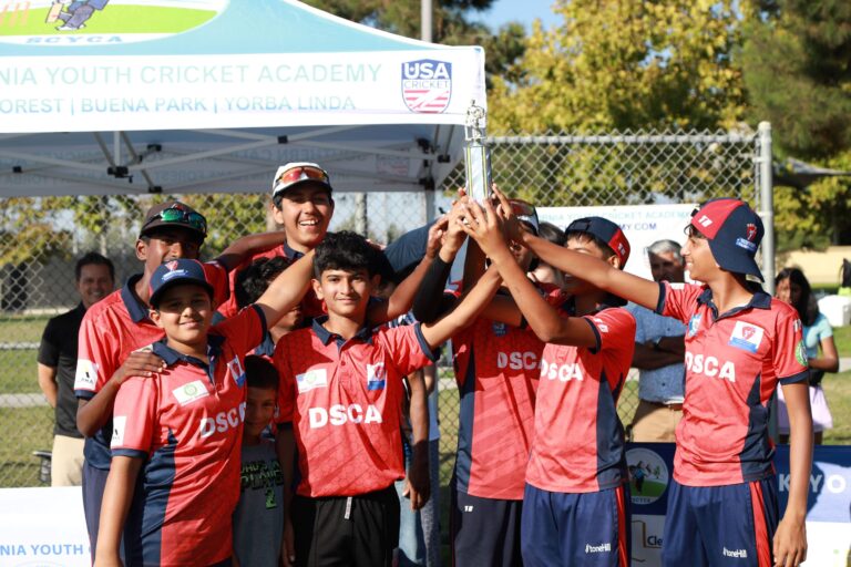 DSCA Youth Cricket Players in Red Jerseys Lifting Trophy