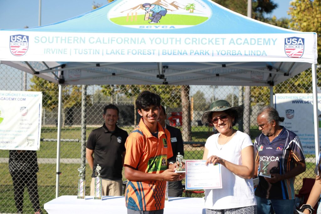 Trophy being handed to youth cricket player